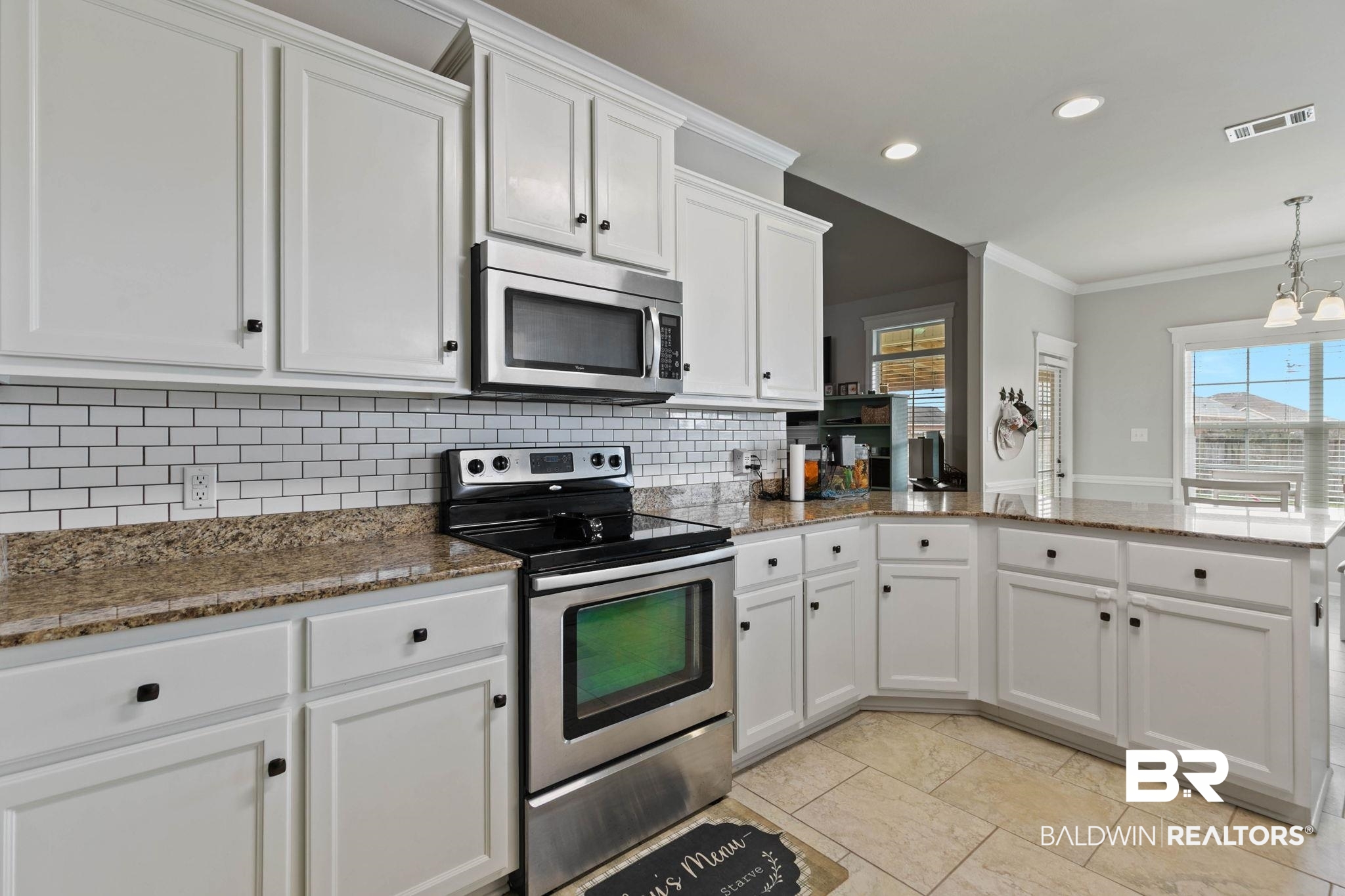 9177 Labrador Trail Theodore, AL 36582 - Photo 10 of 24 Kitchen featuring stainless steel appliances, crown molding, white cabinetry, a peninsula, and dark stone countertops