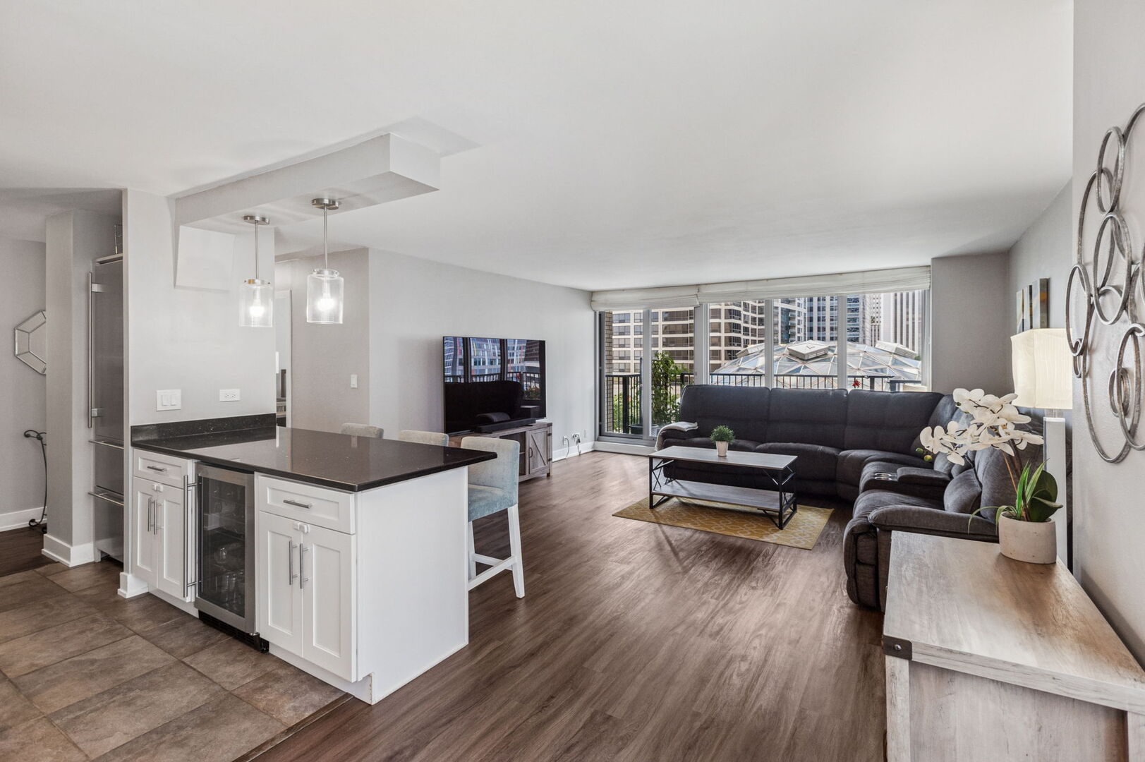 400 East Randolph Street, Unit 930 Chicago, IL 60601 - Photo 7 of 34 a kitchen with stainless steel appliances kitchen island granite countertop a stove a refrigerator a dining table and chairs with wooden floor