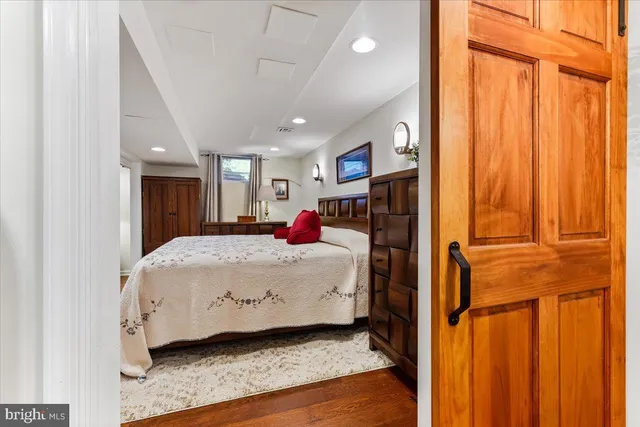 a large bedroom with a bed and wooden floor