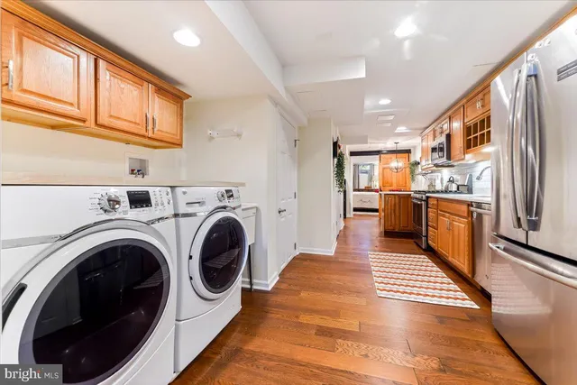 a view of a kitchen with stainless steel appliances lots of counter top space and wooden floor