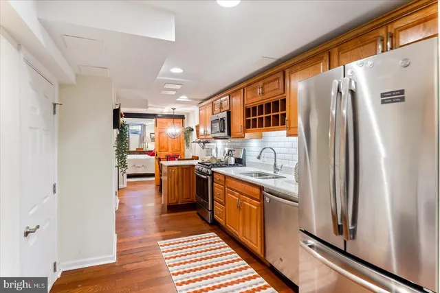 a kitchen with stainless steel appliances granite countertop a refrigerator and a sink
