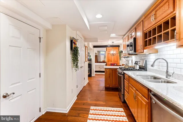 a kitchen with stainless steel appliances a sink stove refrigerator and cabinets