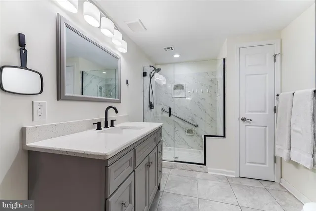 a bathroom with a sink vanity granite shower and a mirror