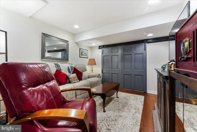 a living room with furniture a flat screen tv and a window