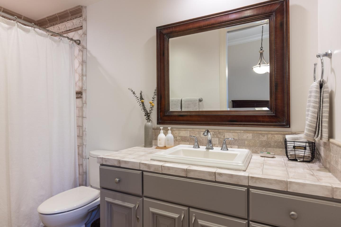 19831 Spring Ridge Terrace Salinas, CA 93908 - Photo 28 of 49 a bathroom with a granite countertop sink a toilet and a mirror