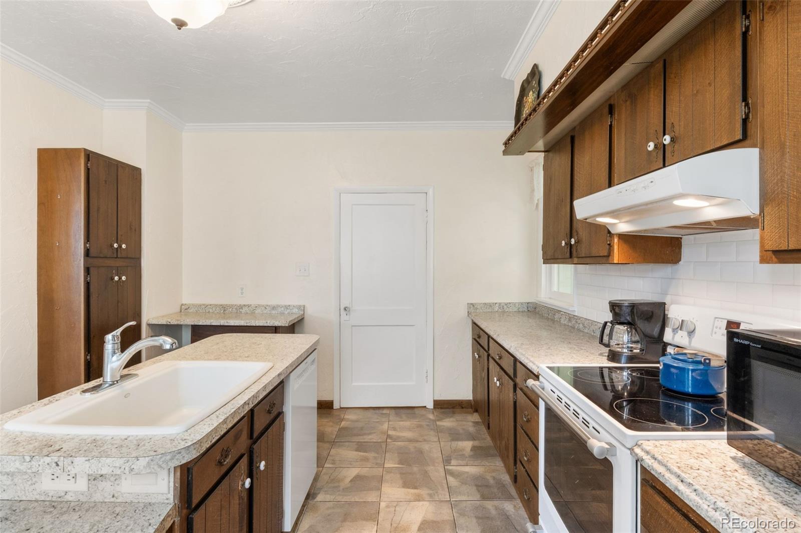 6044 Columbine Street Rye, CO 81069 - Photo 15 of 31 a kitchen with a sink stove and cabinets