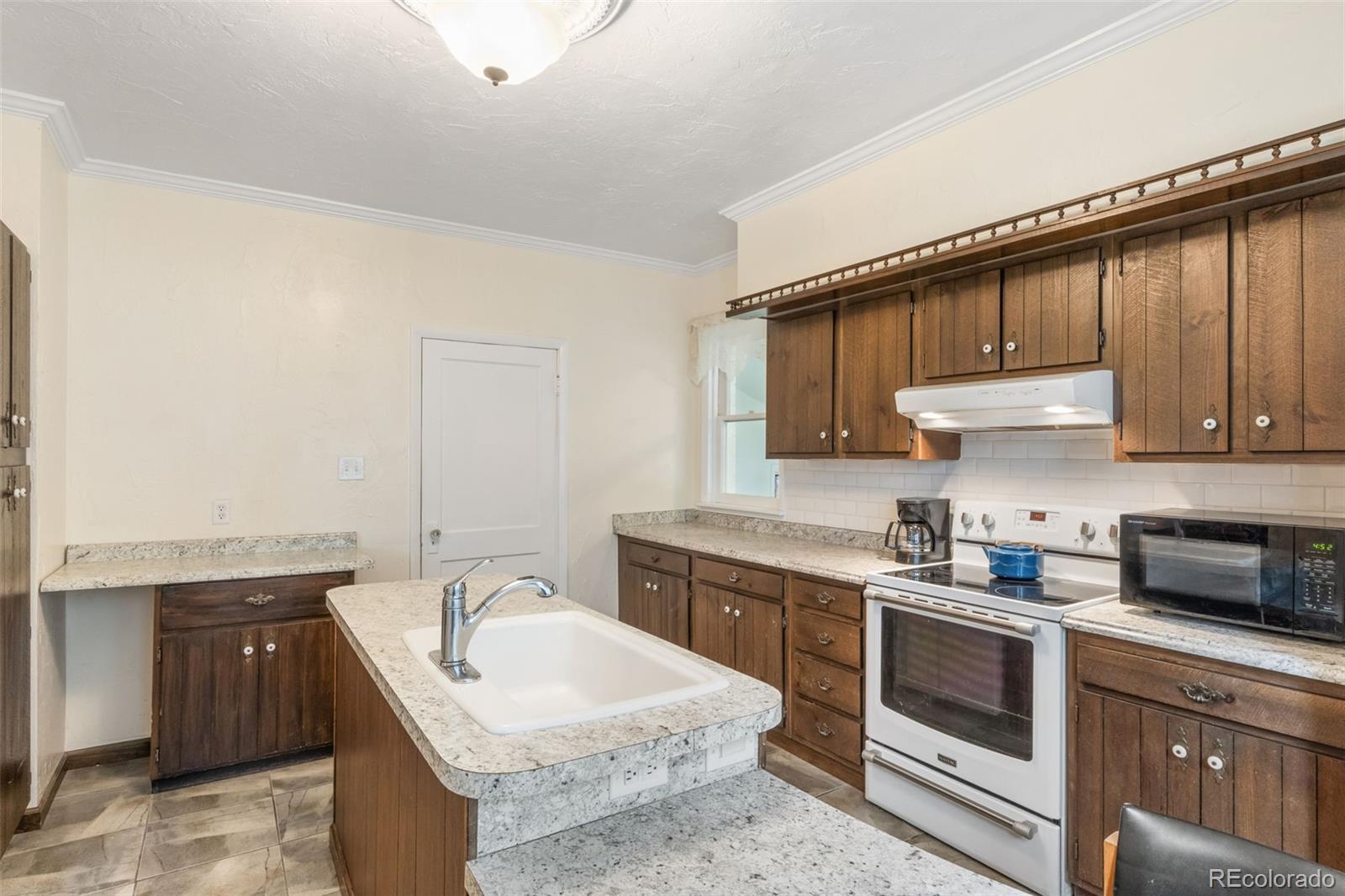 6044 Columbine Street Rye, CO 81069 - Photo 17 of 31 a kitchen with a sink stove top oven and cabinets