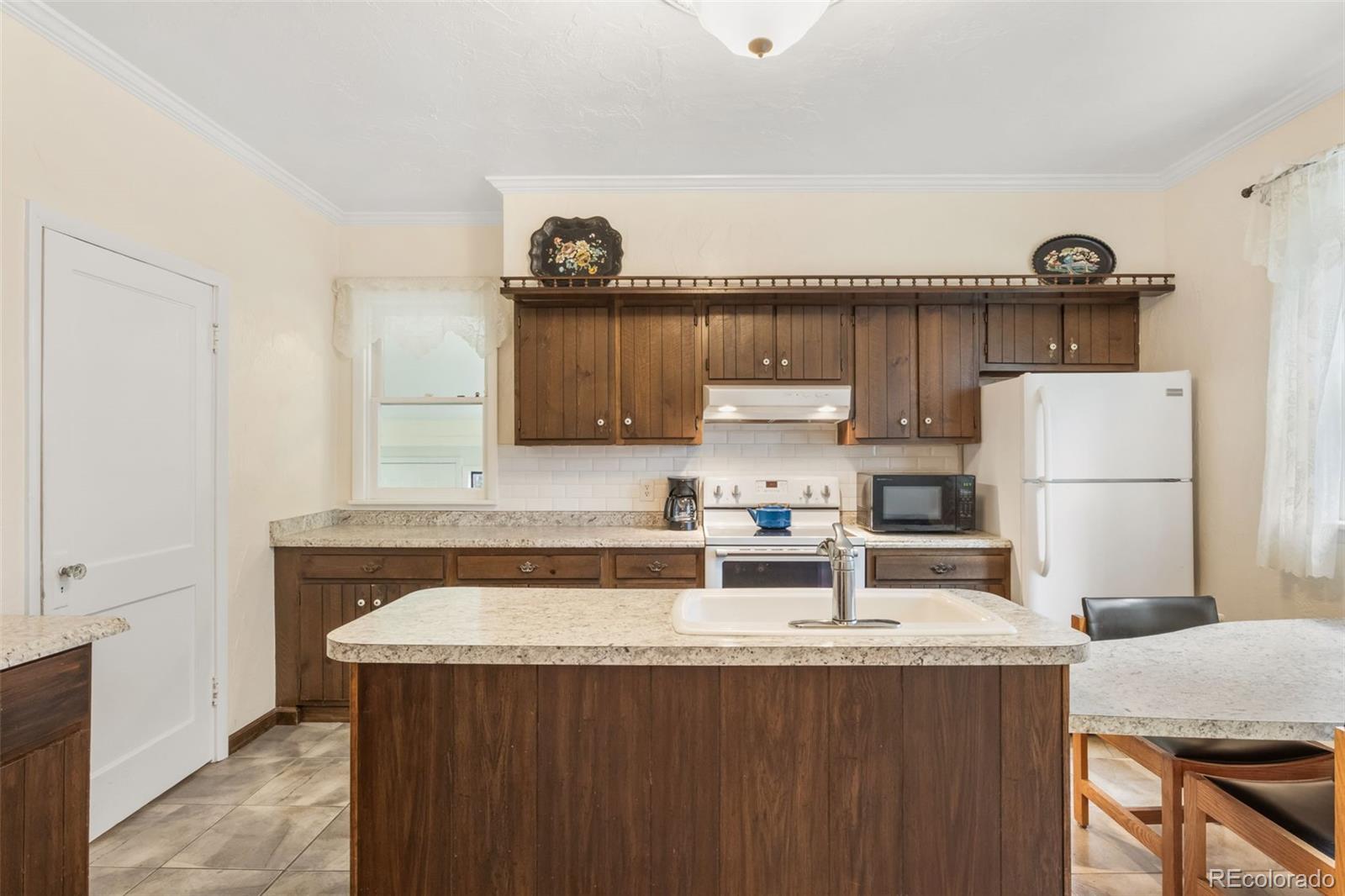 6044 Columbine Street Rye, CO 81069 - Photo 18 of 31 a kitchen with kitchen island a stove a sink and a refrigerator