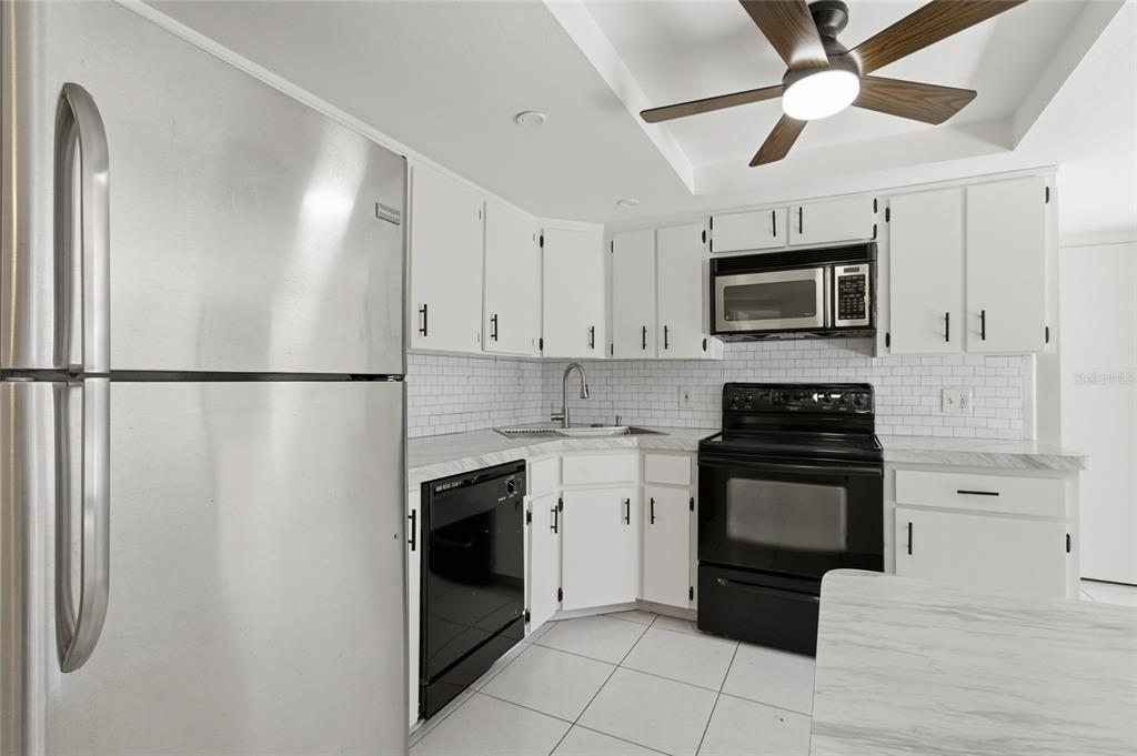 7230 San Moritz Drive Port Richey, FL 34668 - Photo 11 of 25 a kitchen with stainless steel appliances granite countertop a refrigerator a stove top oven a sink and dishwasher