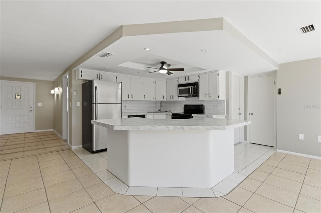 7230 San Moritz Drive Port Richey, FL 34668 - Photo 9 of 25 a kitchen with stainless steel appliances a refrigerator and a stove top oven