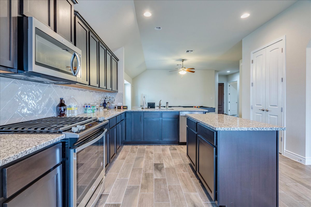 124 Compass Lane Kyle, TX 78640 - Photo 12 of 38 a kitchen with stainless steel appliances granite countertop a stove and a sink