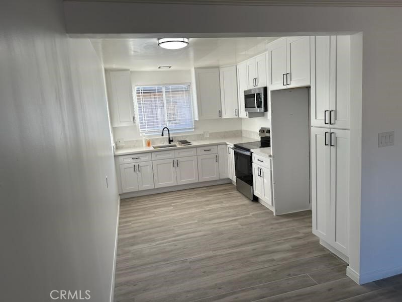 527 Cedar Avenue, Unit 2C Long Beach, CA 90802 - Photo 17 of 29 a kitchen with stainless steel appliances granite countertop a stove top oven a sink and white cabinets