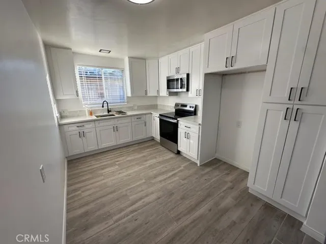 a kitchen with white cabinets and white appliances