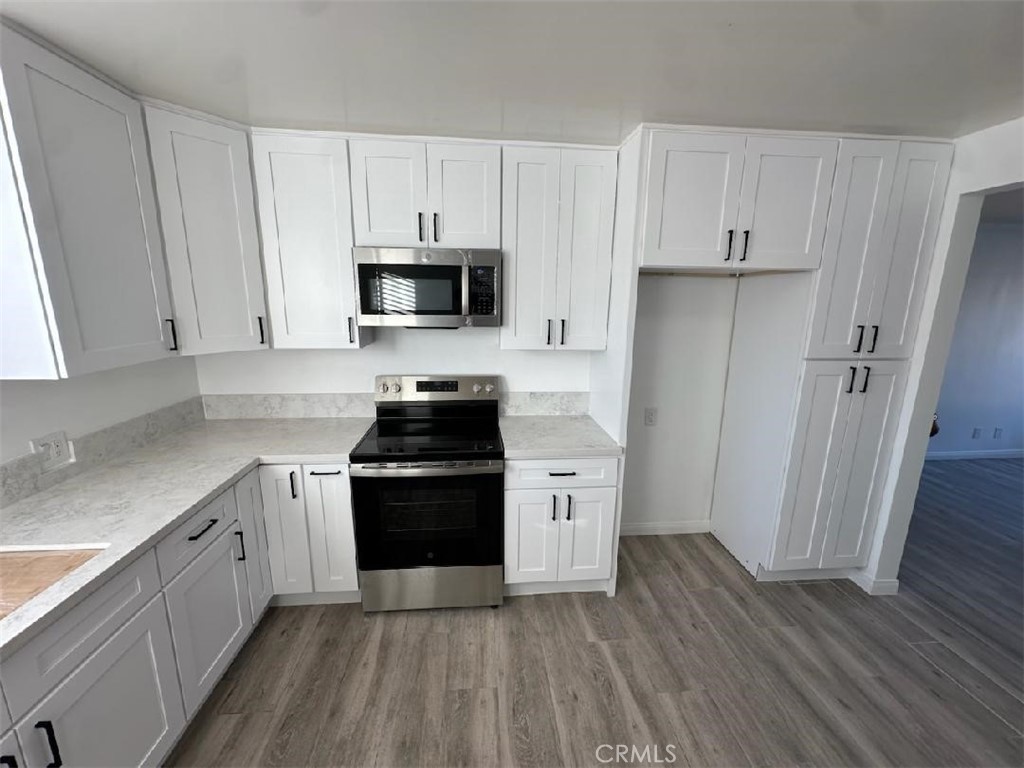 527 Cedar Avenue, Unit 2C Long Beach, CA 90802 - Photo 2 of 29 a kitchen with granite countertop white cabinets and stainless steel appliances