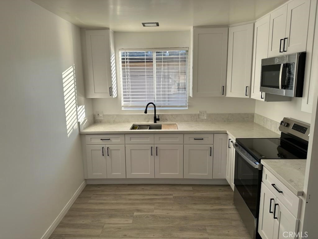527 Cedar Avenue, Unit 2C Long Beach, CA 90802 - Photo 22 of 29 a kitchen with granite countertop a sink white cabinets and stainless steel appliances