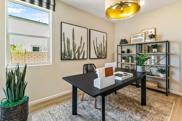 a view of a workspace room with wooden floor and dining table