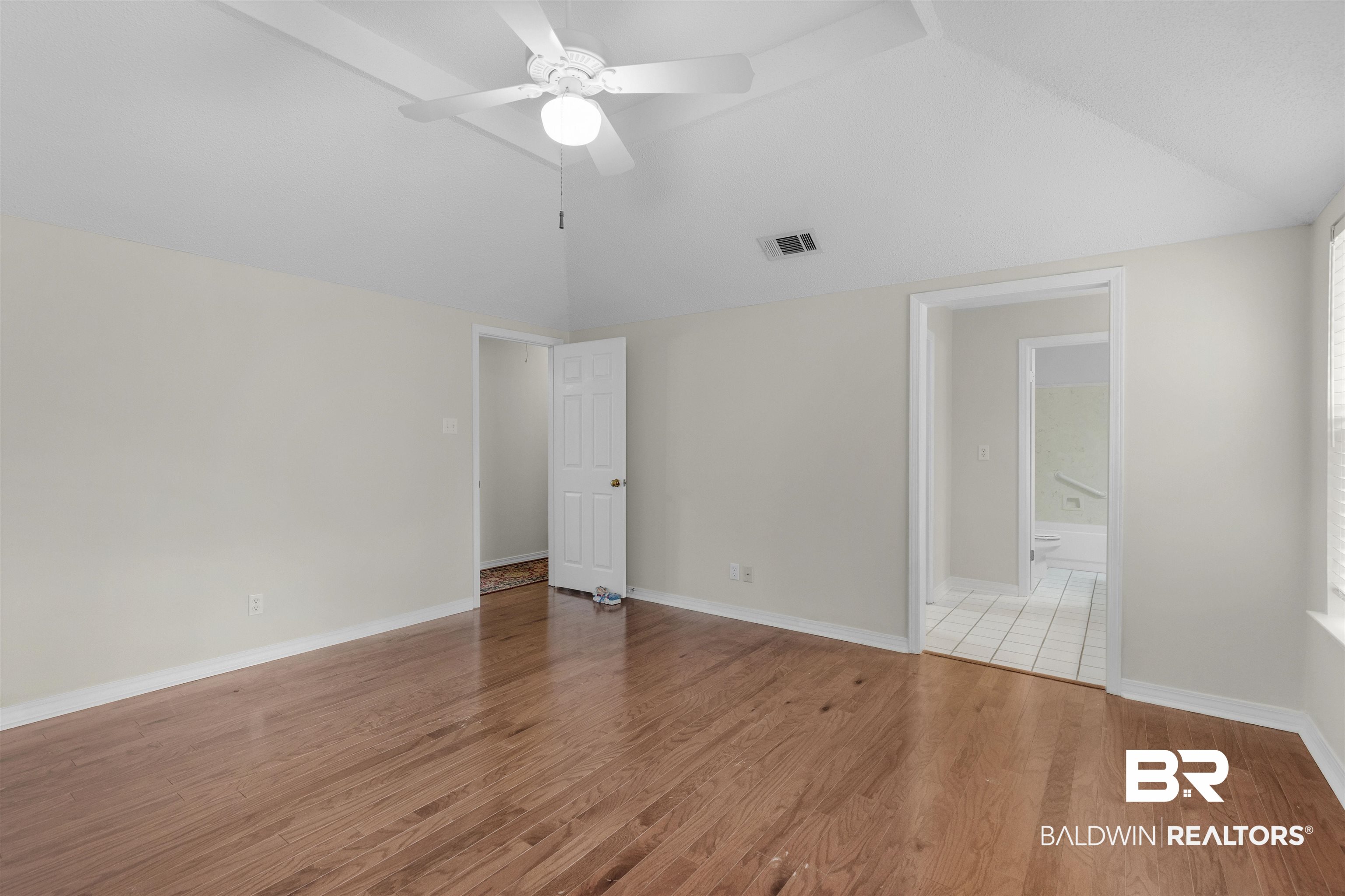 7225 Smithfield Road East Mobile, AL 36695 - Photo 17 of 27 Unfurnished room featuring visible vents, a ceiling fan, light wood-style floors, and lofted ceiling