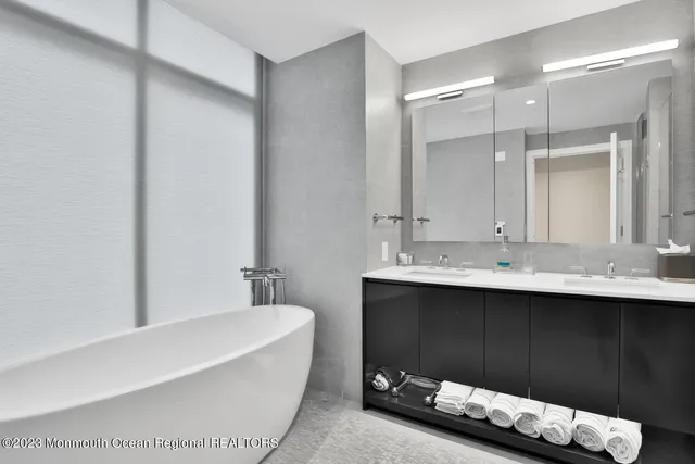 a bathroom with a bathtub sink and a mirror