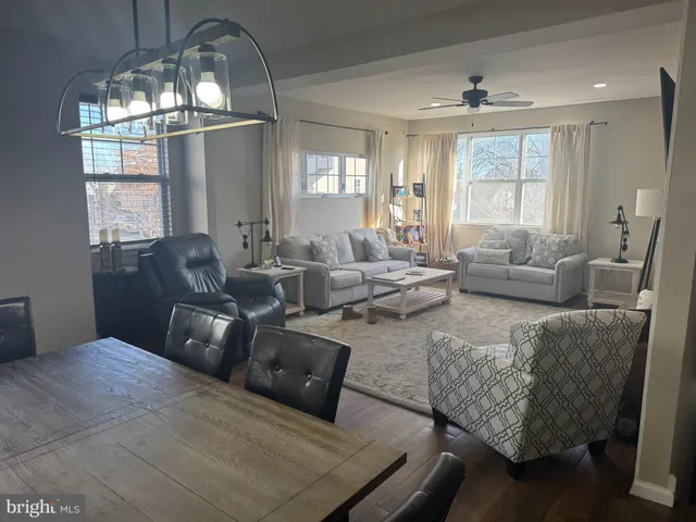 a living room with furniture wooden floor and a chandelier