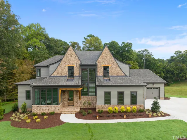 a front view of a house with a yard and potted plants