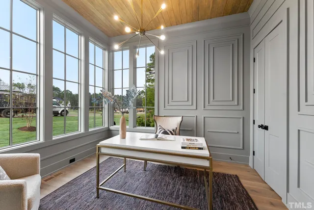a living room with furniture a large window with table and chairs