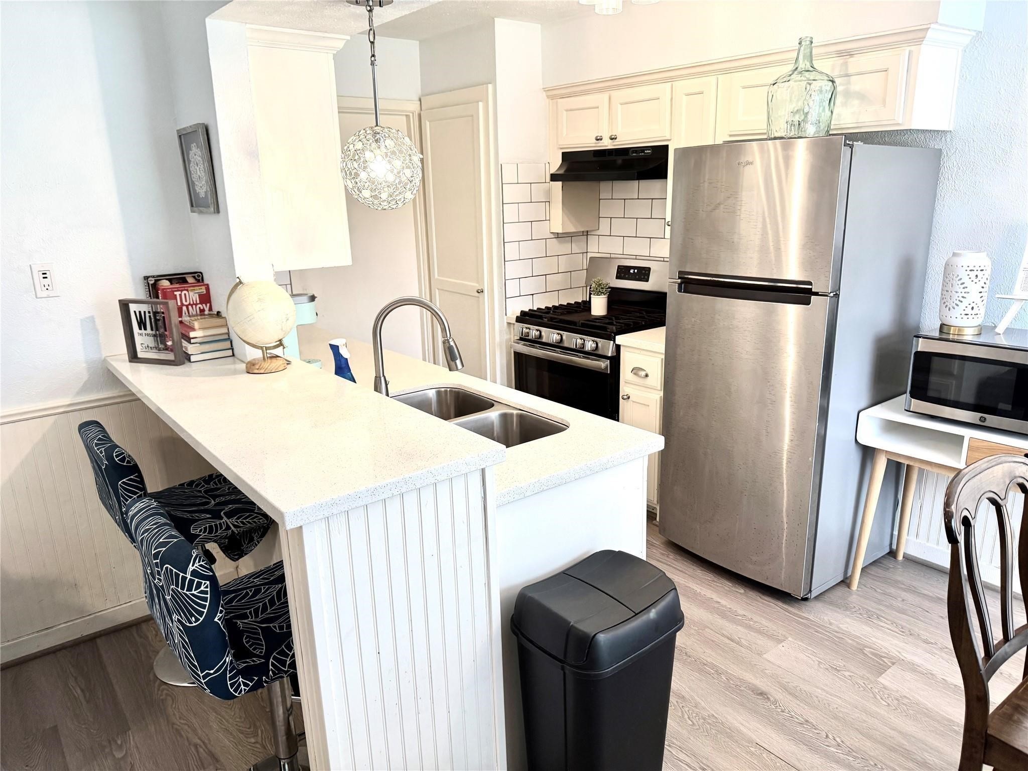 11311 Caribbean Lane Houston, TX 77089 - Photo 6 of 21 a kitchen with granite countertop a refrigerator and a stove top oven