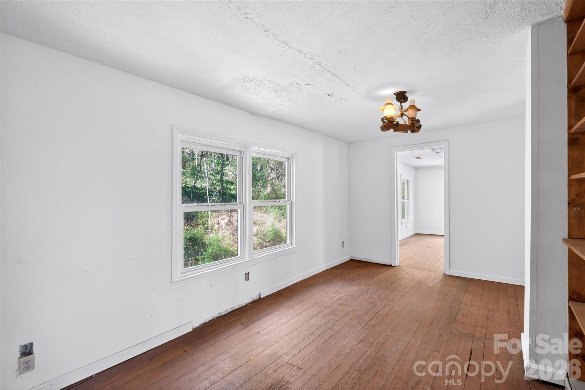 105 Poplar Street Saluda, NC 28773 - Photo 18 of 37 an empty room with a window and wooden floor