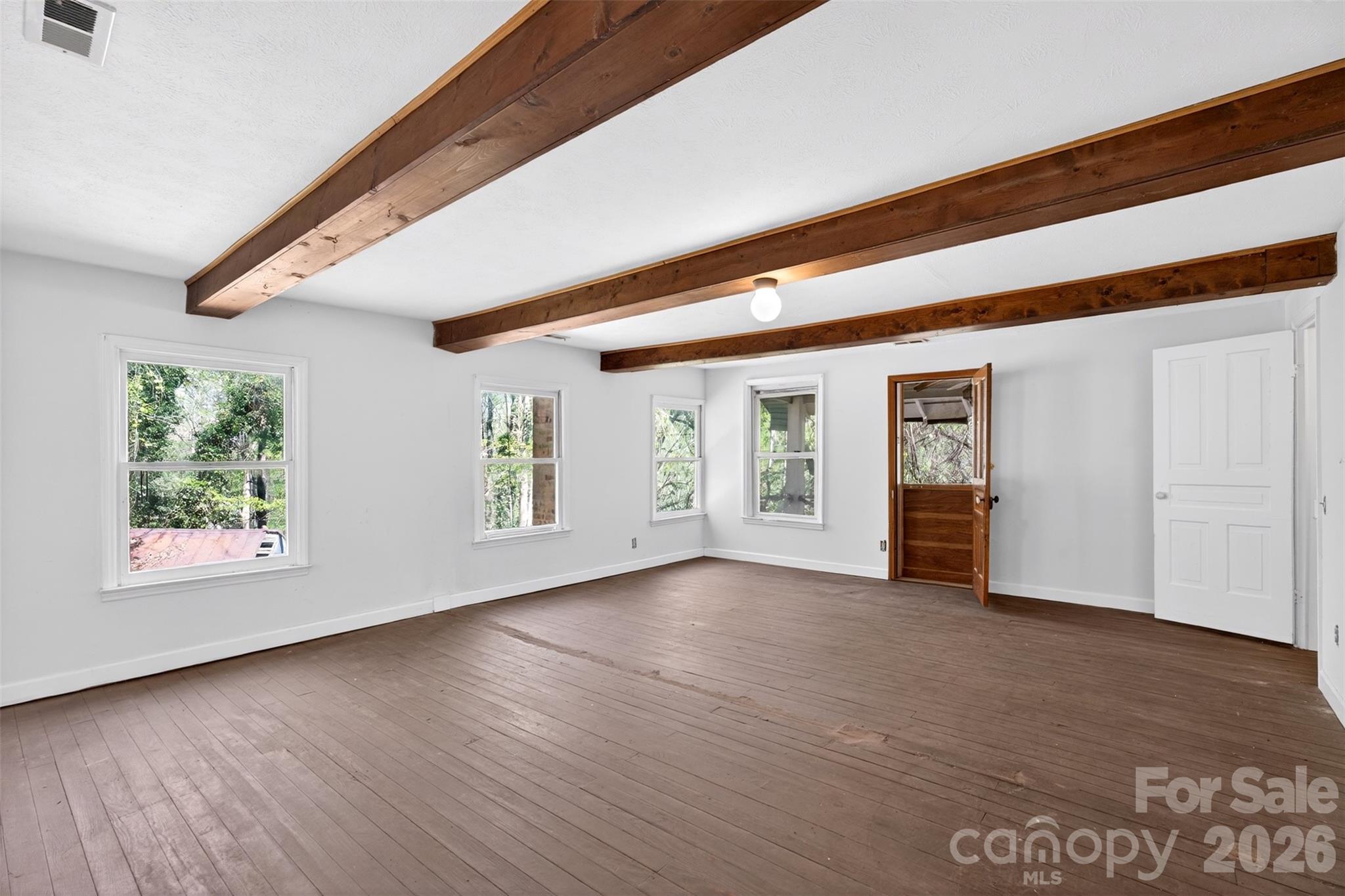 105 Poplar Street Saluda, NC 28773 - Photo 21 of 37 an empty room with wooden floor and windows