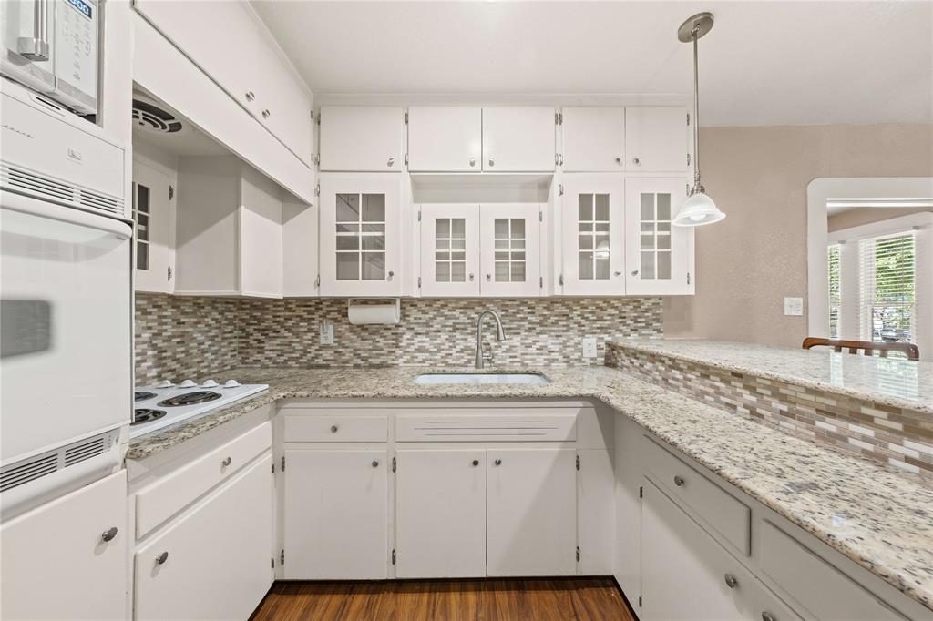 919 North 11th Street Temple, TX 76501 - Photo 11 of 26 a kitchen with granite countertop white cabinets and white appliances