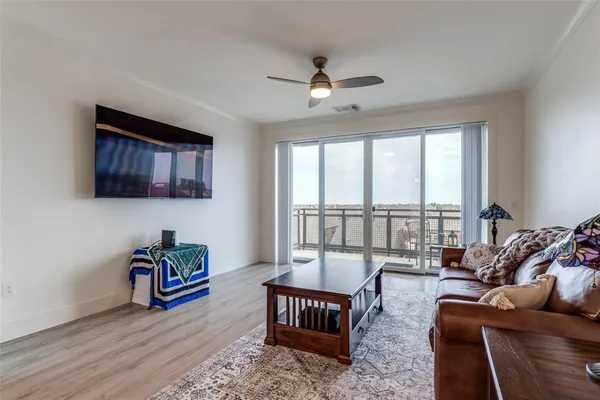 a living room with furniture ceiling fan and a window
