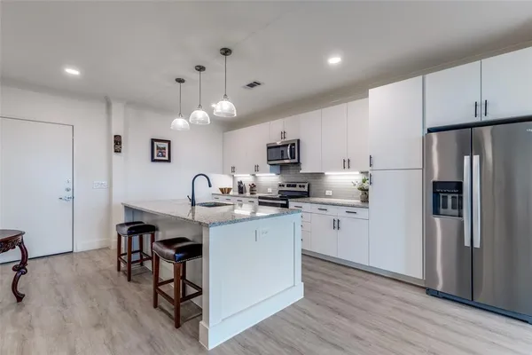 a kitchen with white cabinets and stainless steel appliances