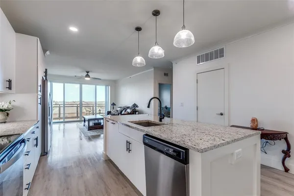 a kitchen that has a lot of cabinets a sink and a stove in it