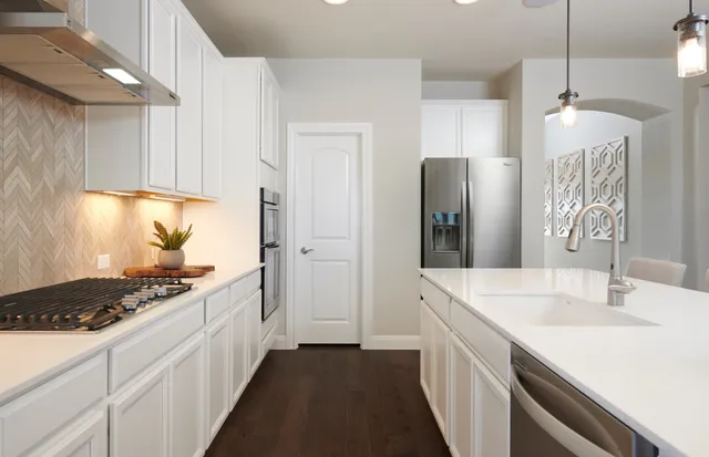 a kitchen with stainless steel appliances a sink stove and refrigerator