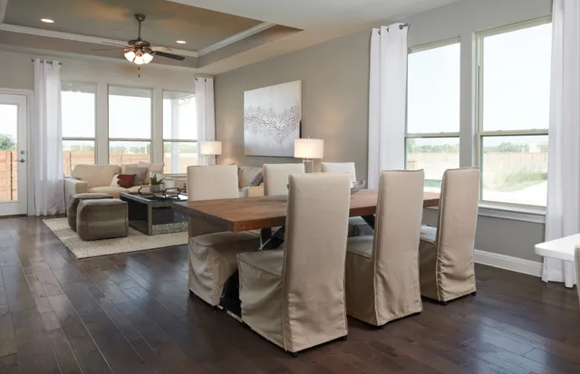 a living room with furniture wooden floor and a floor to ceiling window