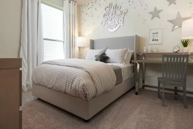 a bed sitting in a bedroom next to a window