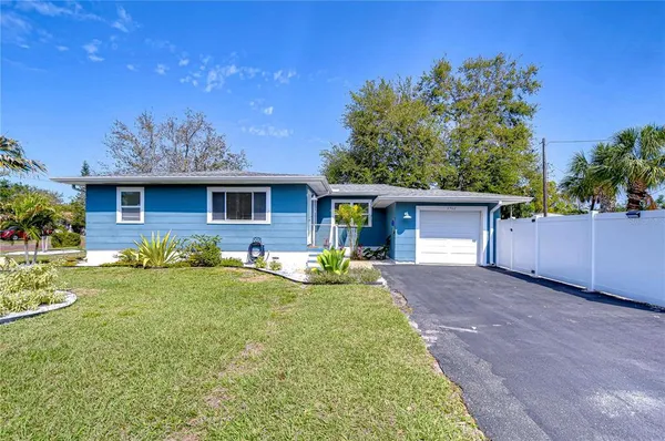 a front view of house with yard and trees around