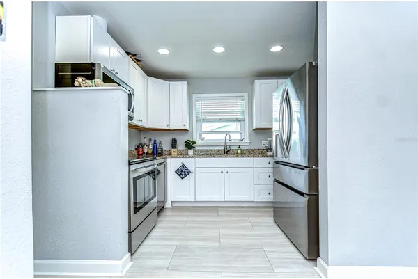 a kitchen with a sink a refrigerator and window