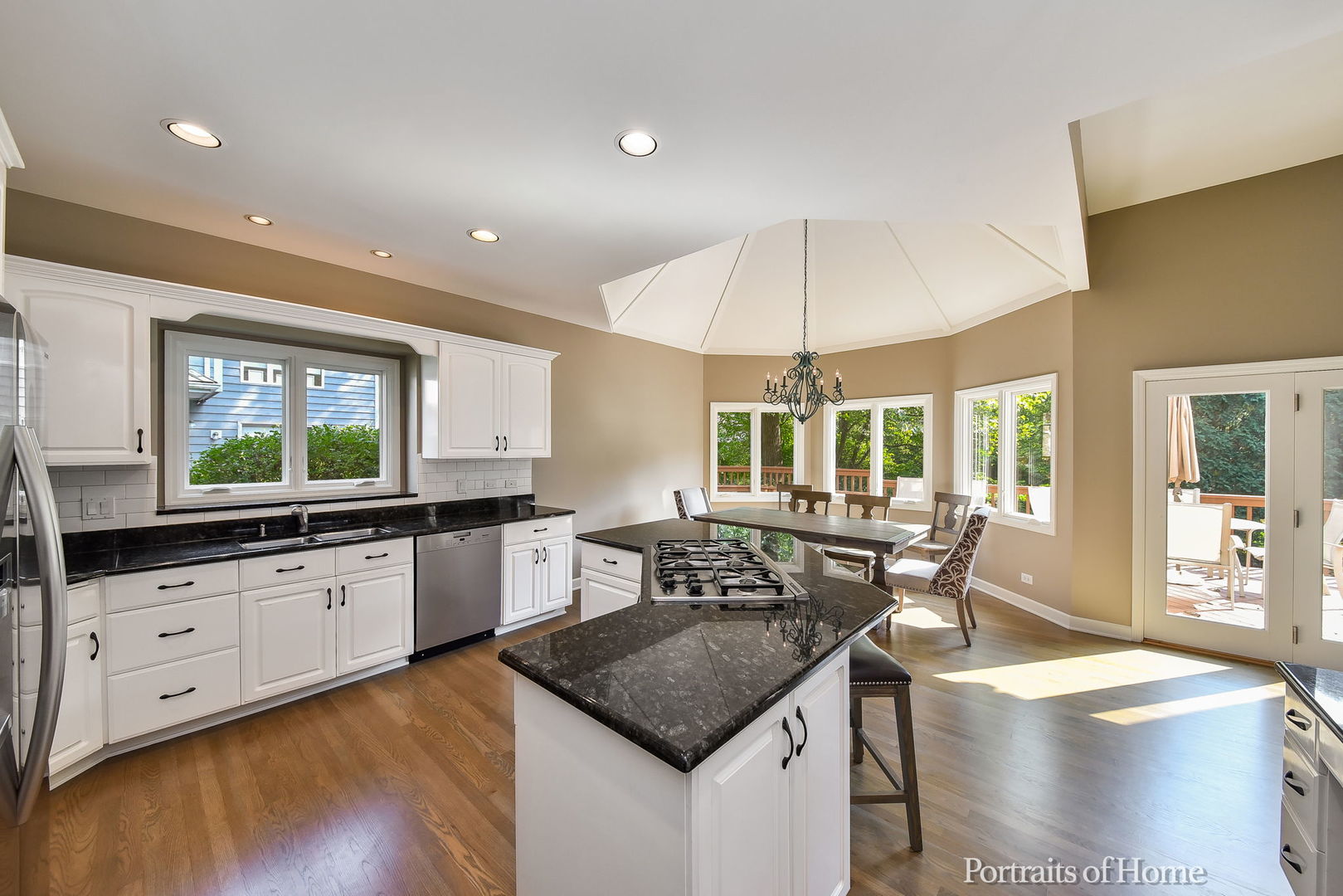 674 East Gartner Road Naperville, IL 60540 - Photo 11 of 36 a kitchen with granite countertop a stove a sink a dining table and chairs with wooden floor