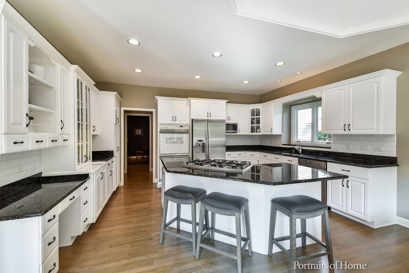 674 East Gartner Road Naperville, IL 60540 - Photo 12 of 36 a kitchen with stainless steel appliances kitchen island granite countertop a stove a sink a refrigerator and white cabinets