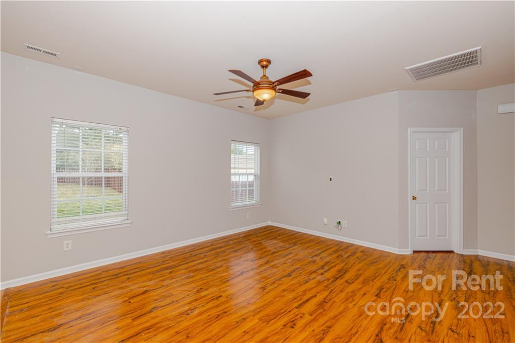 3329 Burnage Hall Road Harrisburg, NC 28075 - Photo 16 of 47 a view of empty room with wooden floor and fan