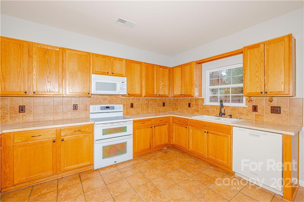 3329 Burnage Hall Road Harrisburg, NC 28075 - Photo 19 of 47 a kitchen with a sink cabinets and window