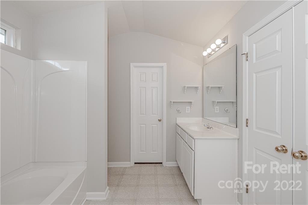 3329 Burnage Hall Road Harrisburg, NC 28075 - Photo 29 of 47 a spacious bathroom with a bathtub sink and mirror
