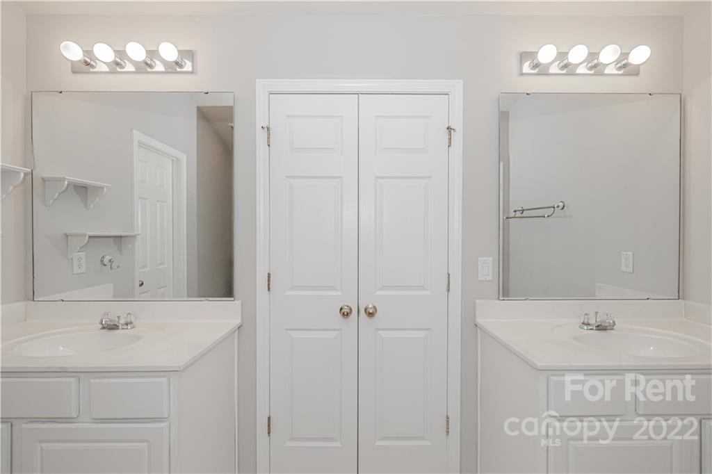 3329 Burnage Hall Road Harrisburg, NC 28075 - Photo 30 of 47 a bathroom with a sink a mirror and a shower