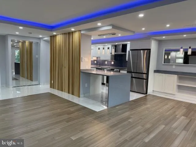 a kitchen with stainless steel appliances granite countertop a refrigerator a stove and a sink