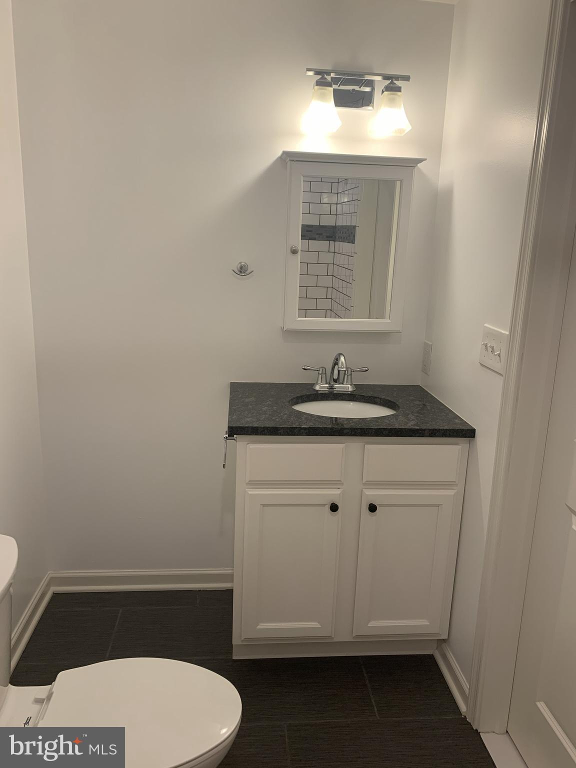 6619 Ridge Avenue, Unit 406 Philadelphia, PA 19128 - Photo 13 of 18 a bathroom with a toilet sink and mirror