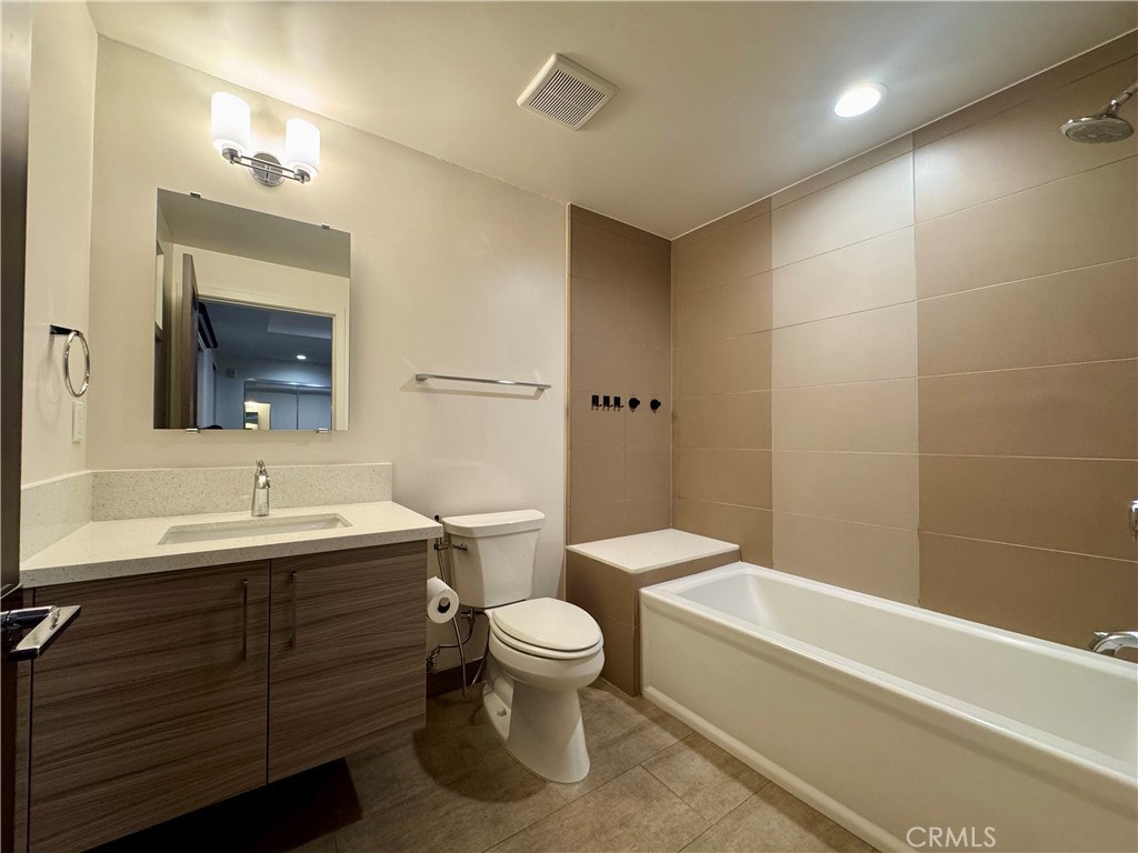 2428 East Del Mar Boulevard, Unit 101 Pasadena, CA 91107 - Photo 12 of 19 a bathroom with a double vanity sink toilet mirror and bathtub