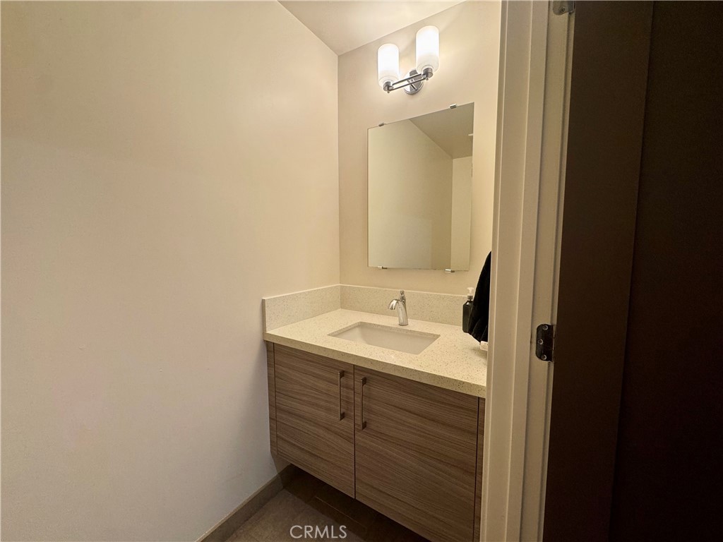 2428 East Del Mar Boulevard, Unit 101 Pasadena, CA 91107 - Photo 15 of 19 a bathroom with a granite countertop sink and a mirror