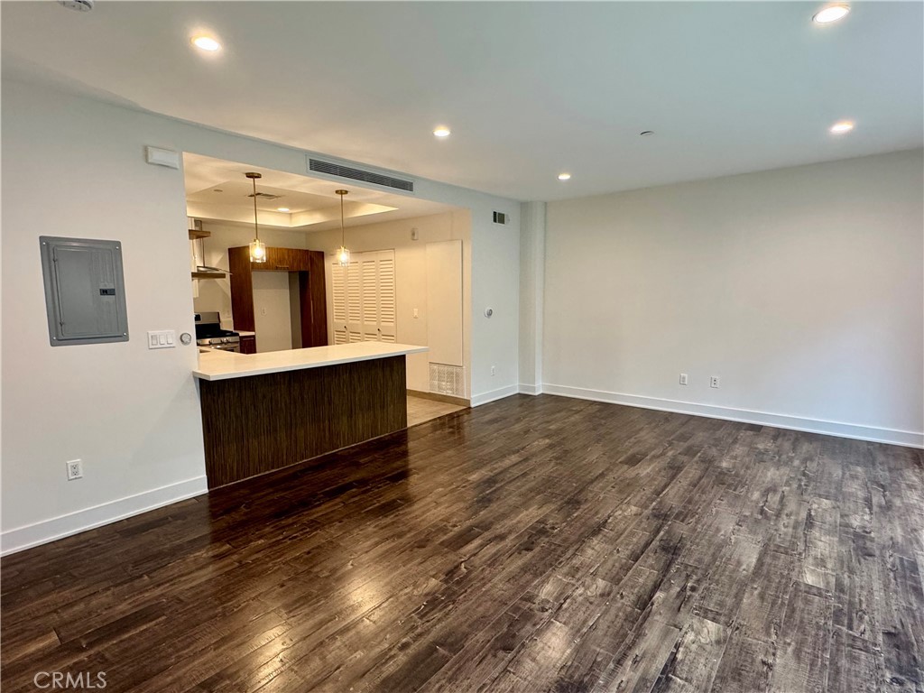 2428 East Del Mar Boulevard, Unit 101 Pasadena, CA 91107 - Photo 3 of 19 an empty room with wooden floor and windows