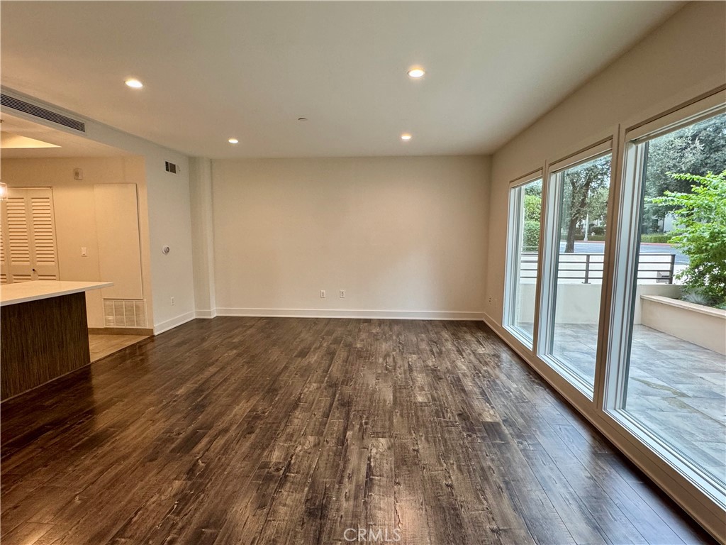 2428 East Del Mar Boulevard, Unit 101 Pasadena, CA 91107 - Photo 4 of 19 a view of an empty room with wooden floor and a window