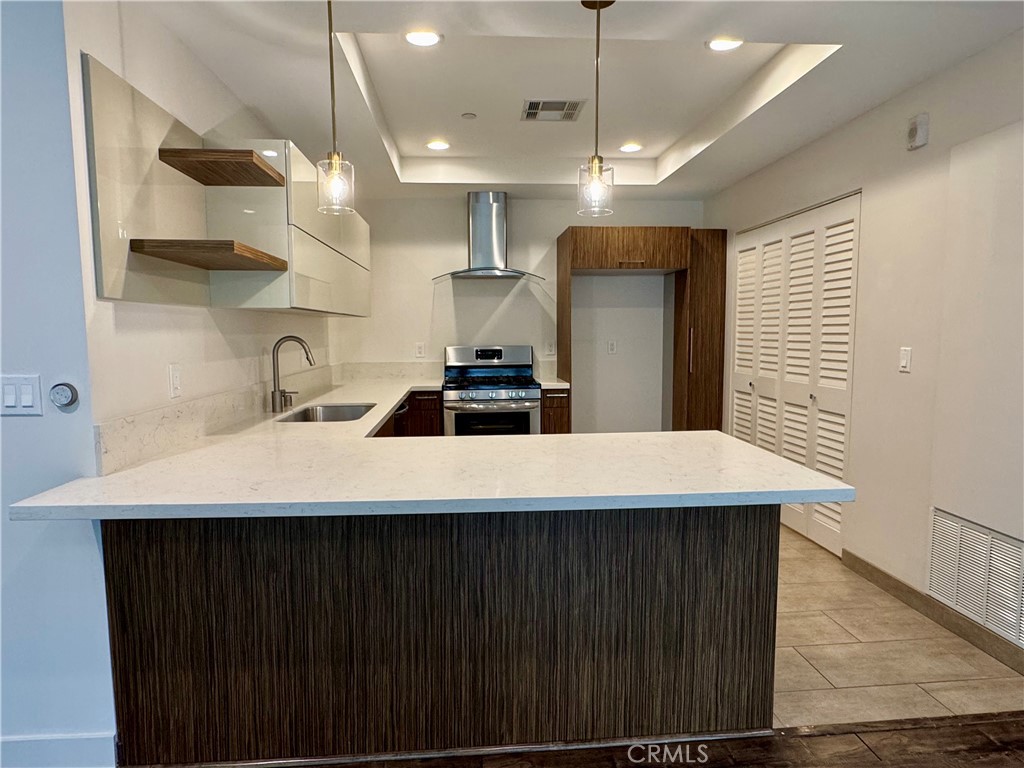 2428 East Del Mar Boulevard, Unit 101 Pasadena, CA 91107 - Photo 6 of 19 a kitchen with stainless steel appliances a sink a refrigerator a center island and chairs